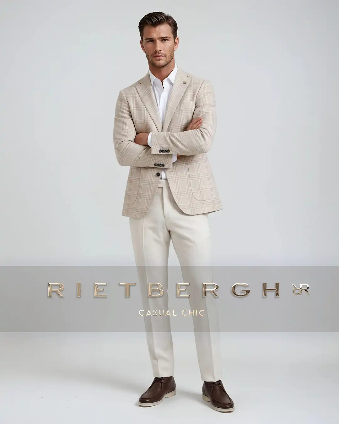 Casual-chic-sta-2026-003 Een man in een casual chic outfit met een blazer met een ruitstof en een wit shirt en beige chino en bruine loafers