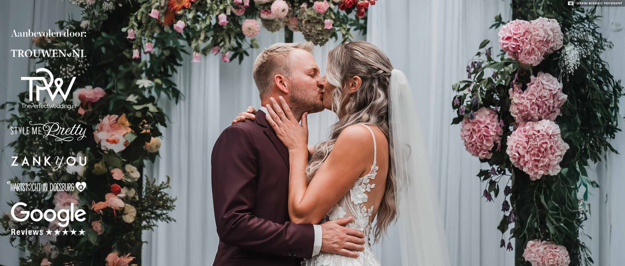 Een bruidegom in een zwart trouwpak voor heren met zijn bruid poserend in de deuropening