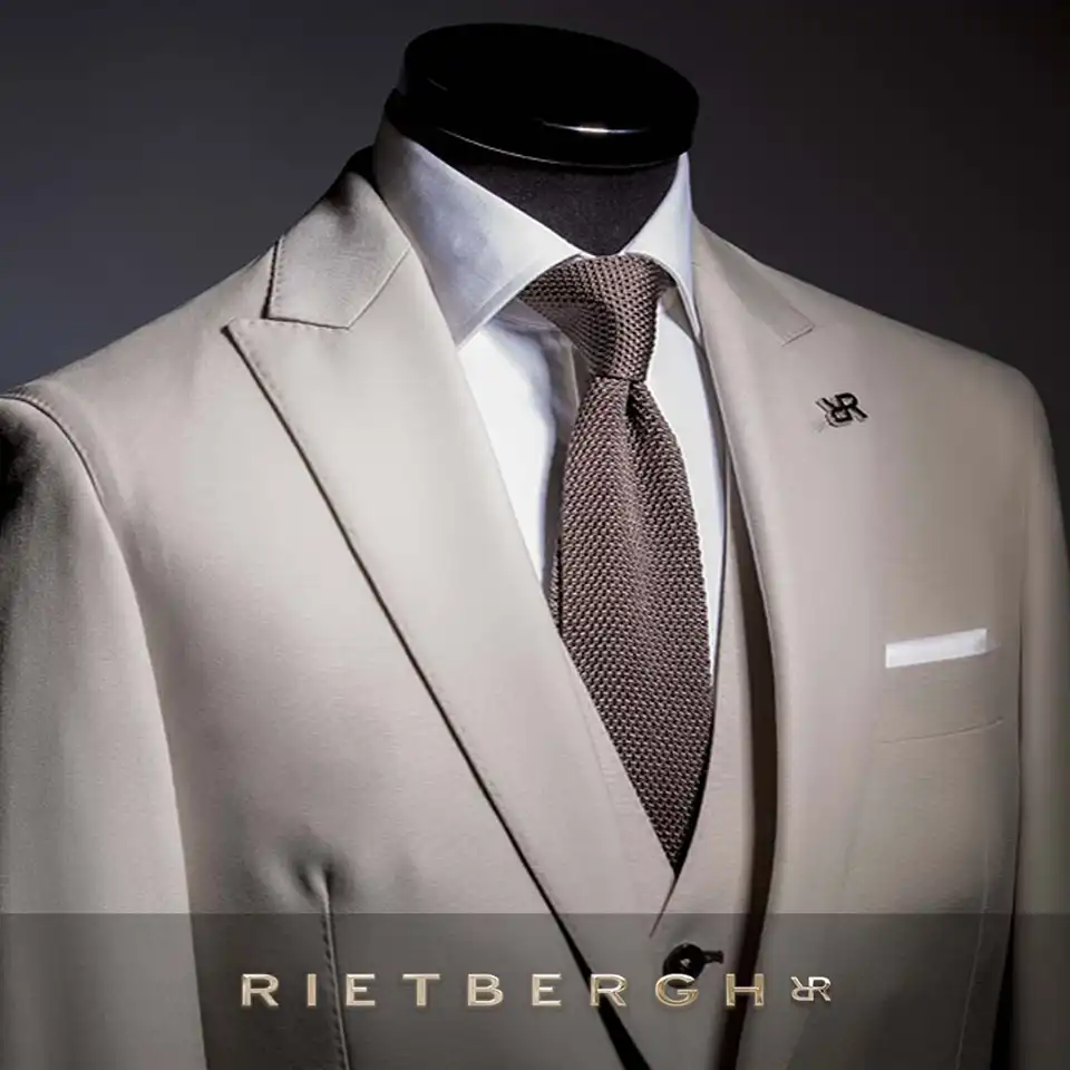 beige_trouwpak_2026-0001 Een driedelig beige trouwpak met een bruine das van Rietbergh trouwpakken