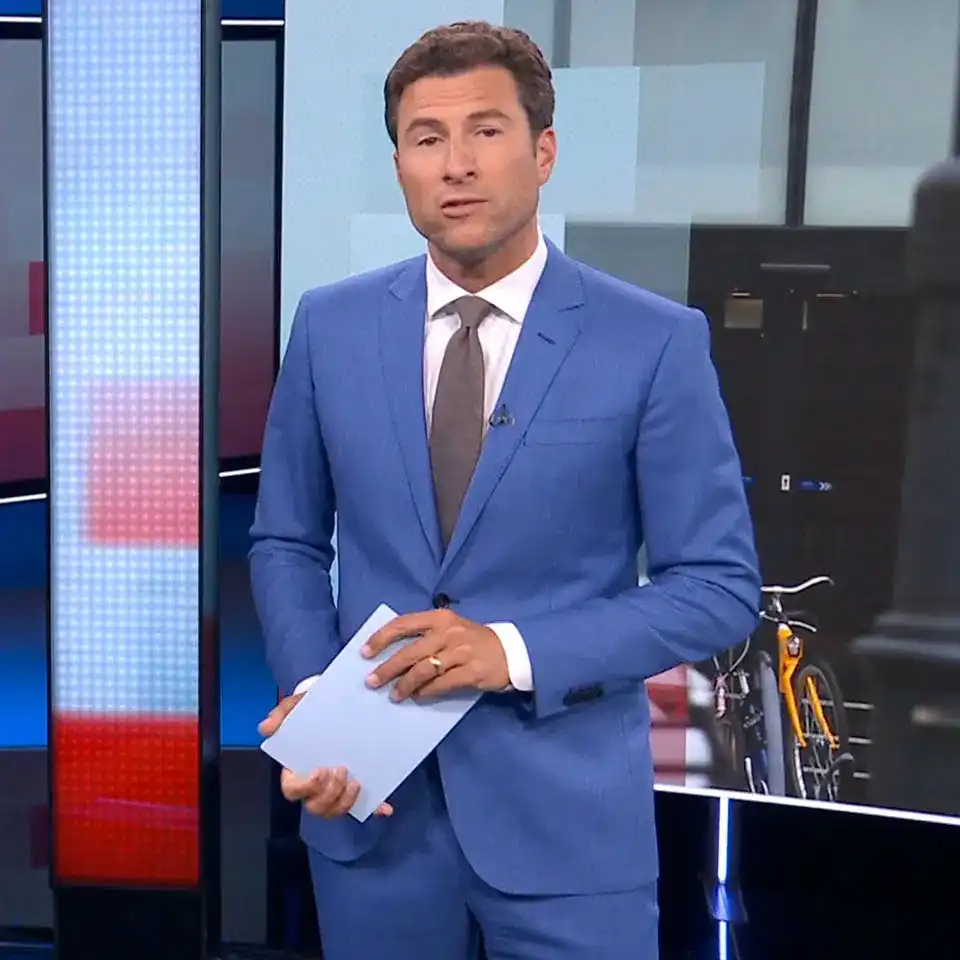 maatpak-klanten-2026-0003 Mark Visser in een middenblauw maatpak van Rietbergh, met een wit shirt en een grijze das in de NOS studio's