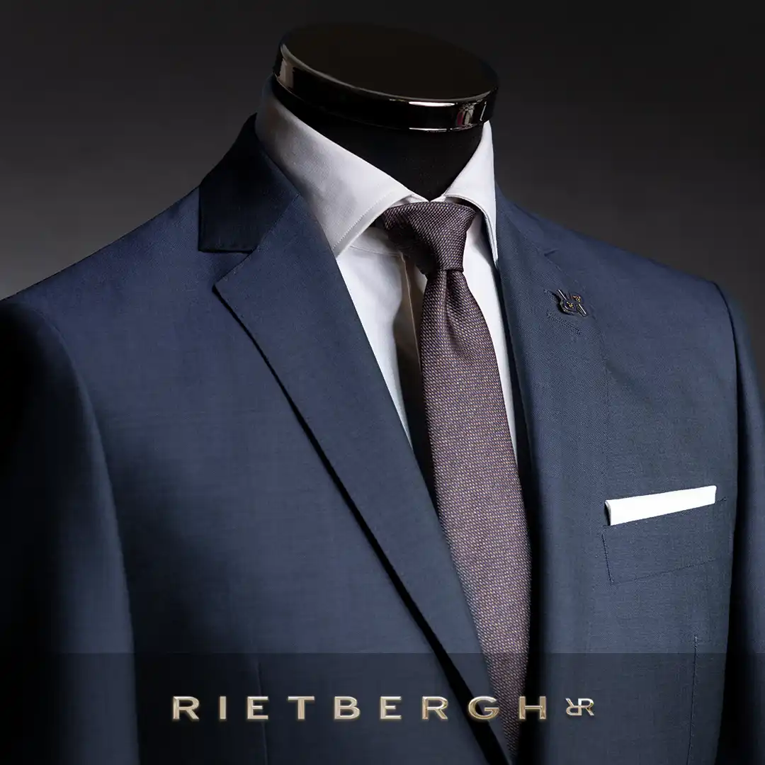 maatpak-title-0001 Een blauw maatpak van Rietbergh met een bruine das en een wit shirt