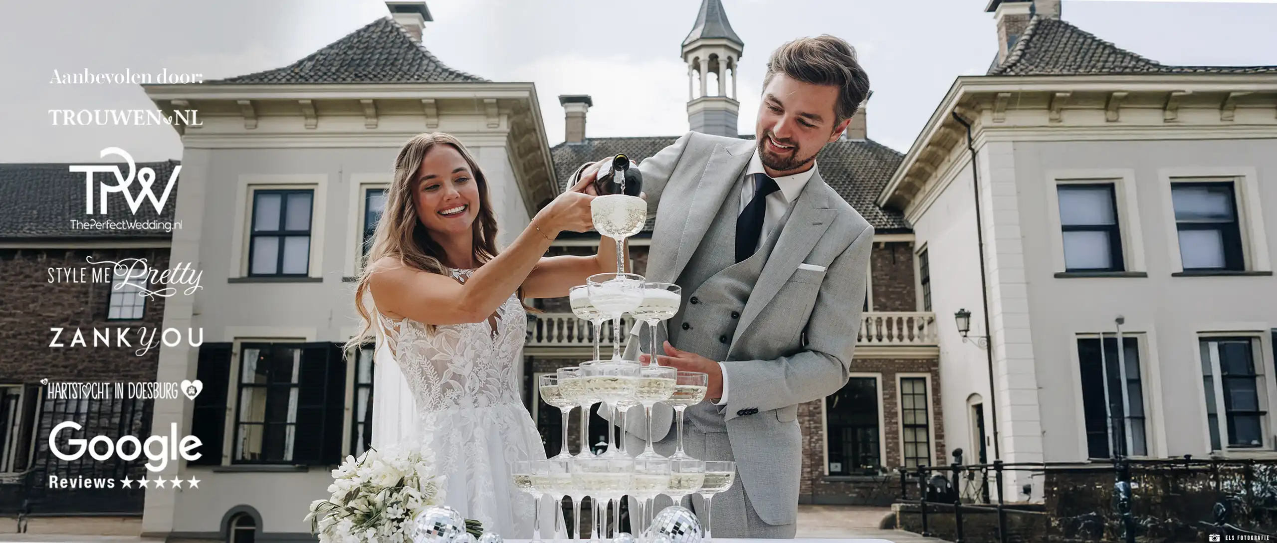 GRIJS-trouwpak-LIG-0001 Een bruidsbaar voor een mooi gebouw die champagne inschenken in een grijs trouwpak.