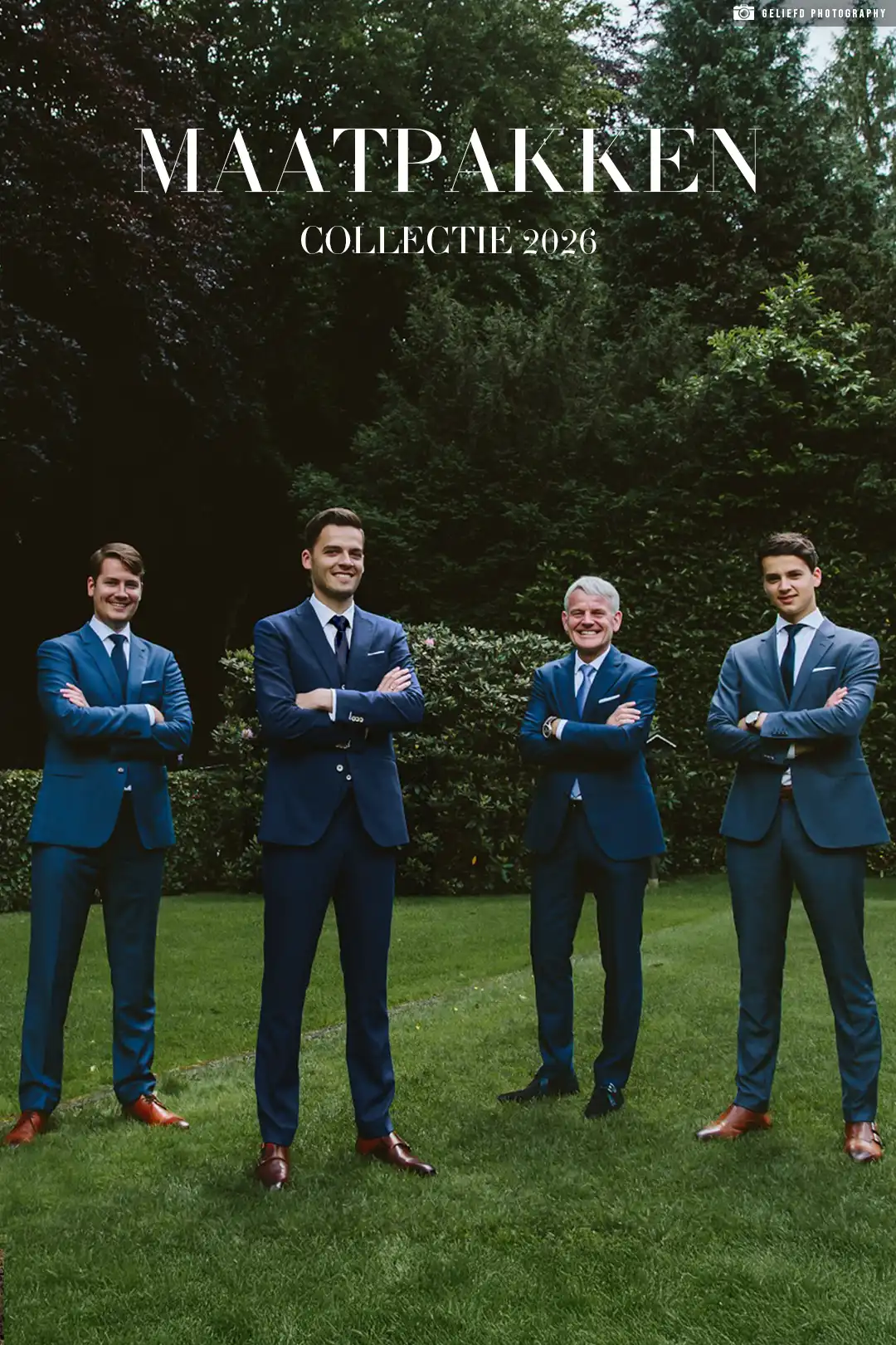 Vader en zijn drie zoons in blauwe maatpakken in een grasveld.