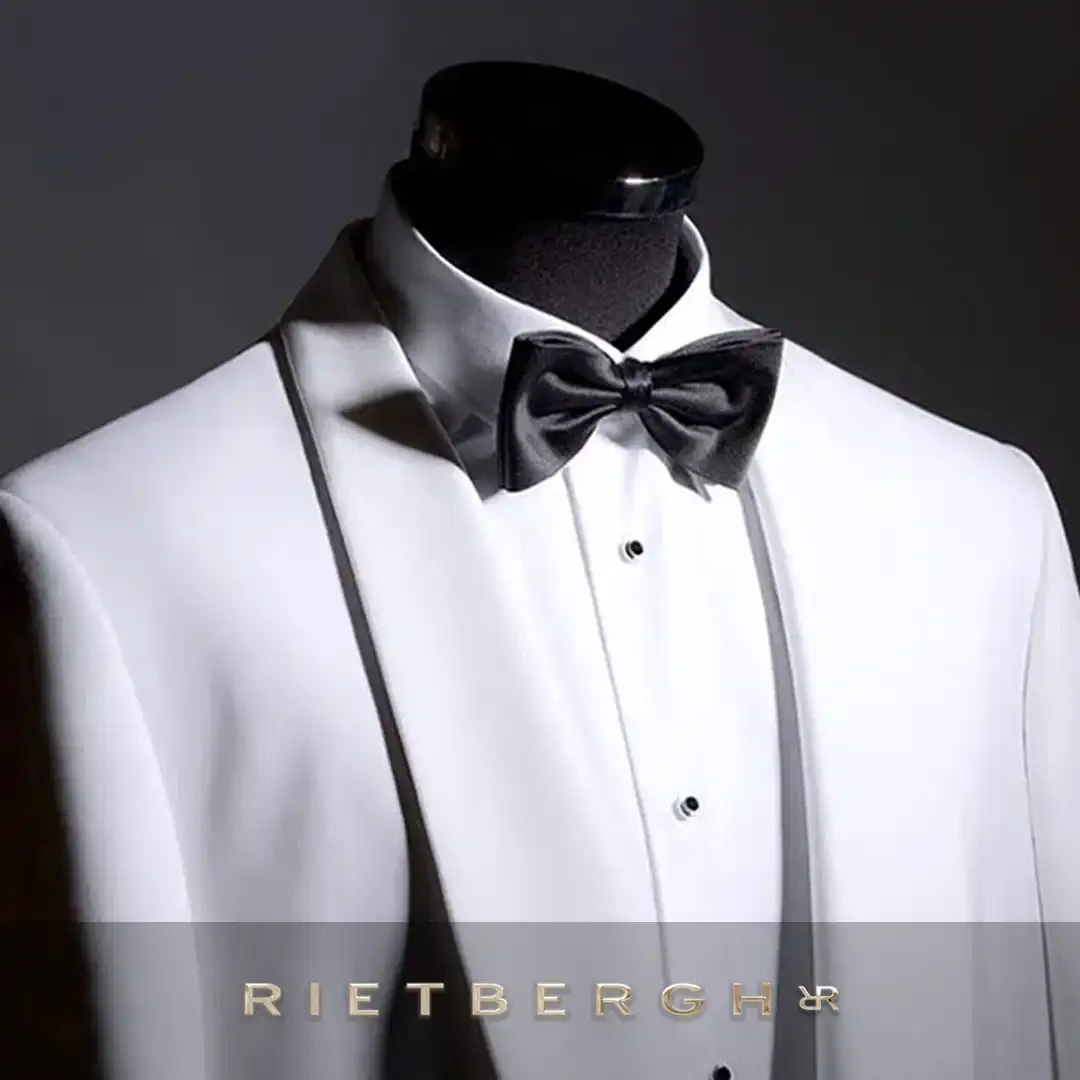 Een witte smoking met een shawlkraag met een zwarte bow tie van Rietbergh